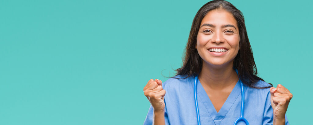 Young arab doctor surgeon woman over isolated background celebrating surprised and amazed for success with arms raised and open eyes. Winner concept.