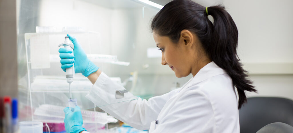 Safety rules. Smart young woman wearing special protective glasses while working in the lab