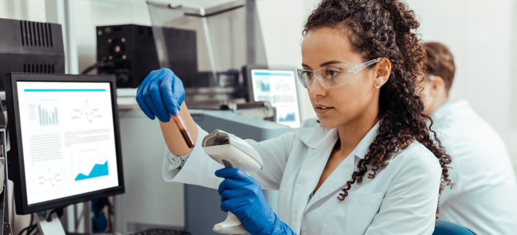 Safety rules. Smart young woman wearing special protective glasses while working in the lab