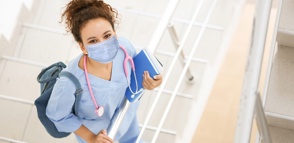 Young African-American student on stairs in clinic