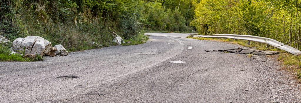 wide shot of damaged asphalt due to falling rocks on the mountain road in the Italian Apennines of the Lazio region