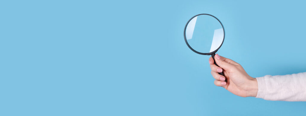 Magnifying glass in hand.