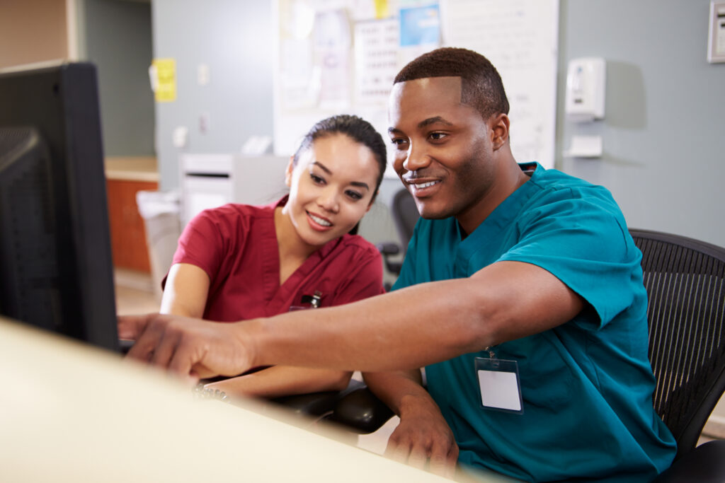 Male And Female Nurse Working At Nurses Station